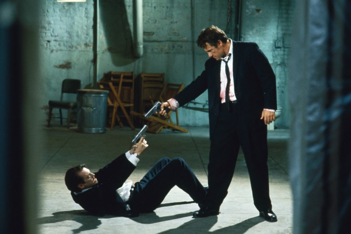 रिज़र्वॉयर डॉग्स में दो आदमी एक दूसरे पर बंदूक तानते हैं।