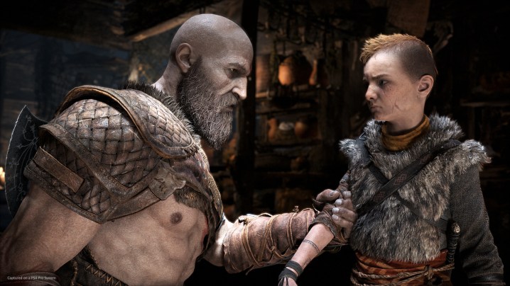 Recensione di Dio della guerra |  Kratos afferra il braccio di Atreus mentre gli parla in una casa