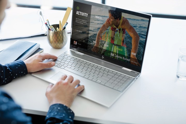 A person uses the HP Envy x360 2-in-1 laptop.