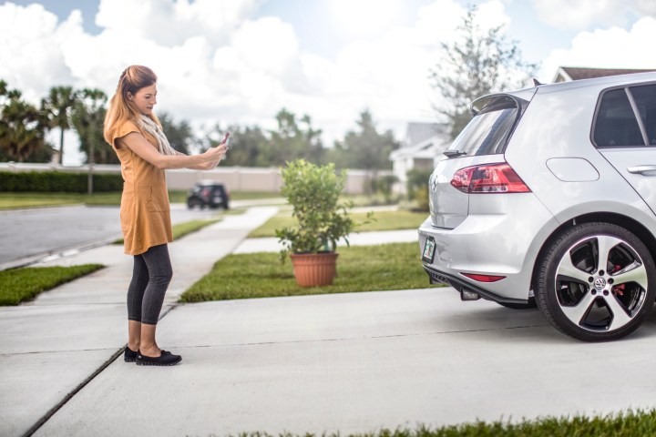 Safe Transaction Zones | Woman takes a photo of her car in preparation to sell it.