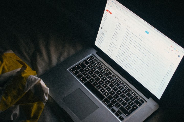 A MacBook running Gmail in a dark room.