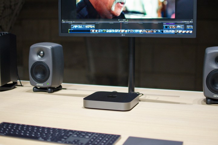 L'Apple Mac Mini 2018 sotto un monitor con due altoparlanti esterni. 