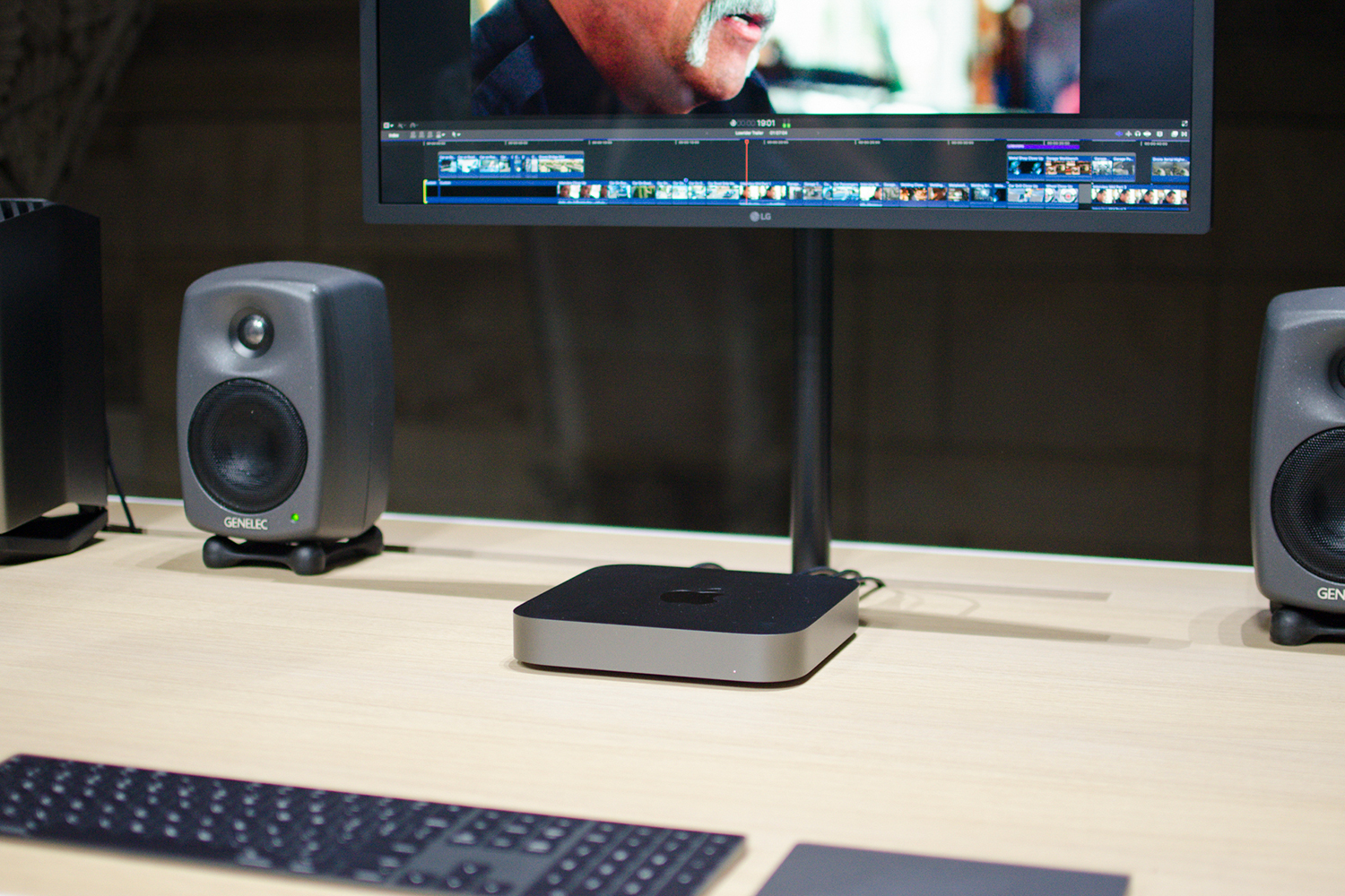 El Apple Mac Mini 2018 bajo un monitor con dos altavoces externos. 