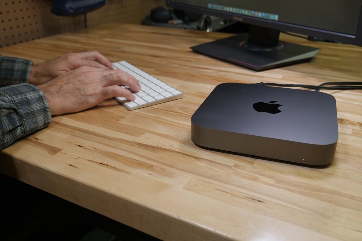 The Apple Mac Mini being used on a wooden desk.