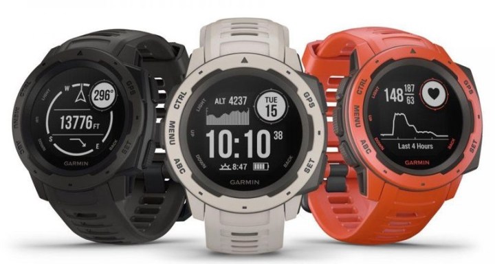 Three Garmin Instinct GPS Smartwatches of various colors sits next to each other on a white background.