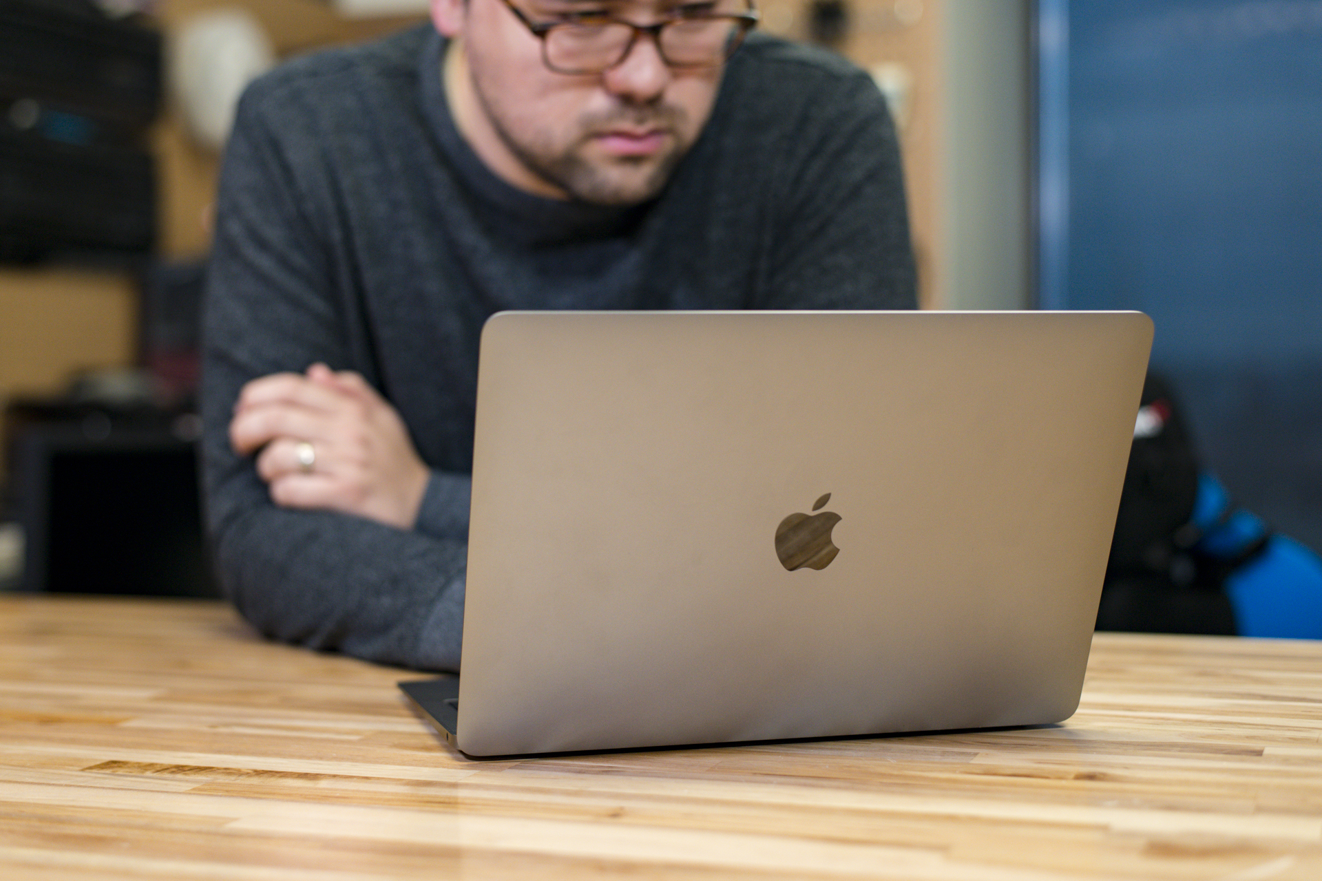 A person working at a 2018 Macbook Air at a wooden table.