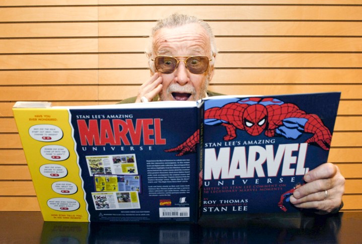 Stan Lee portrait, signing copies of Amazing Marvel Universe