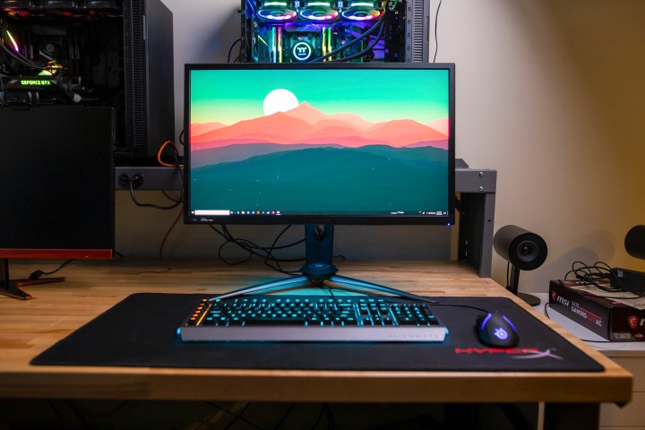 Acer Predator XB3 Gaming Monitor on a desk surrounded by other computer equipment.