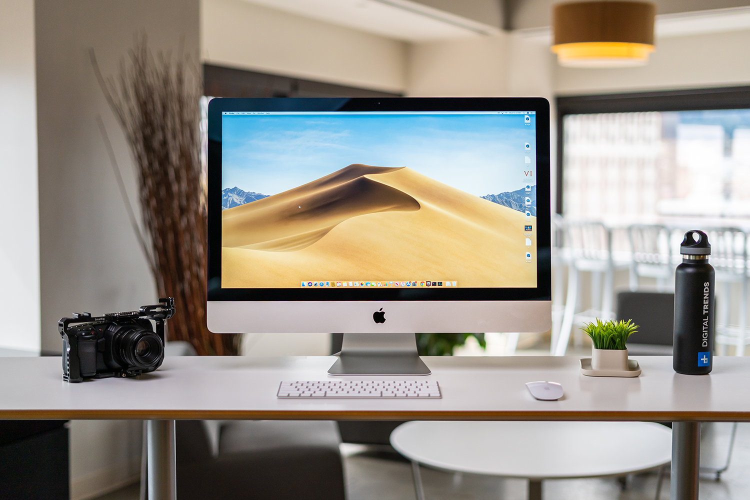 Um Apple iMac de 2019 colocado sobre uma mesa.  O sistema operacional macOS Mojave está em exibição.