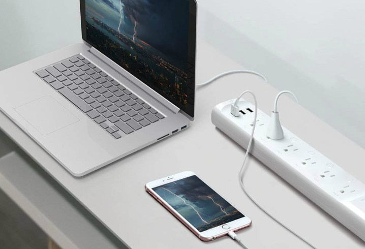An iPhone and a MacBook connected to the Kasa Smart WiFi Power Strip by TP-Link.