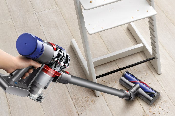 The Dyson V7 Animal cordless vacuum cleaning under a high chair.
