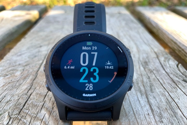Lo smartwatch Garmin Forerunner 945 posizionato su una superficie in legno con il display attivo.