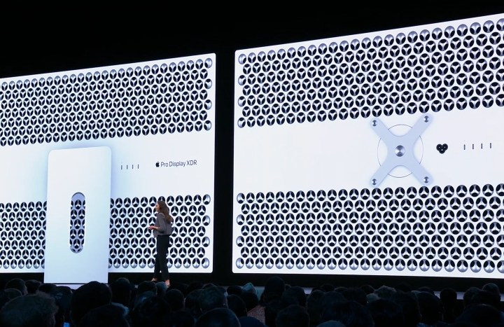 A person onstage at an Apple event with two Pro Display XDR monitors behind them, with the backs of the monitors in view.