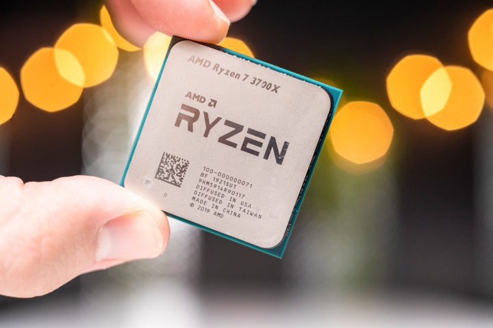 Fingers holding an AMD Ryzen 9 3900X.