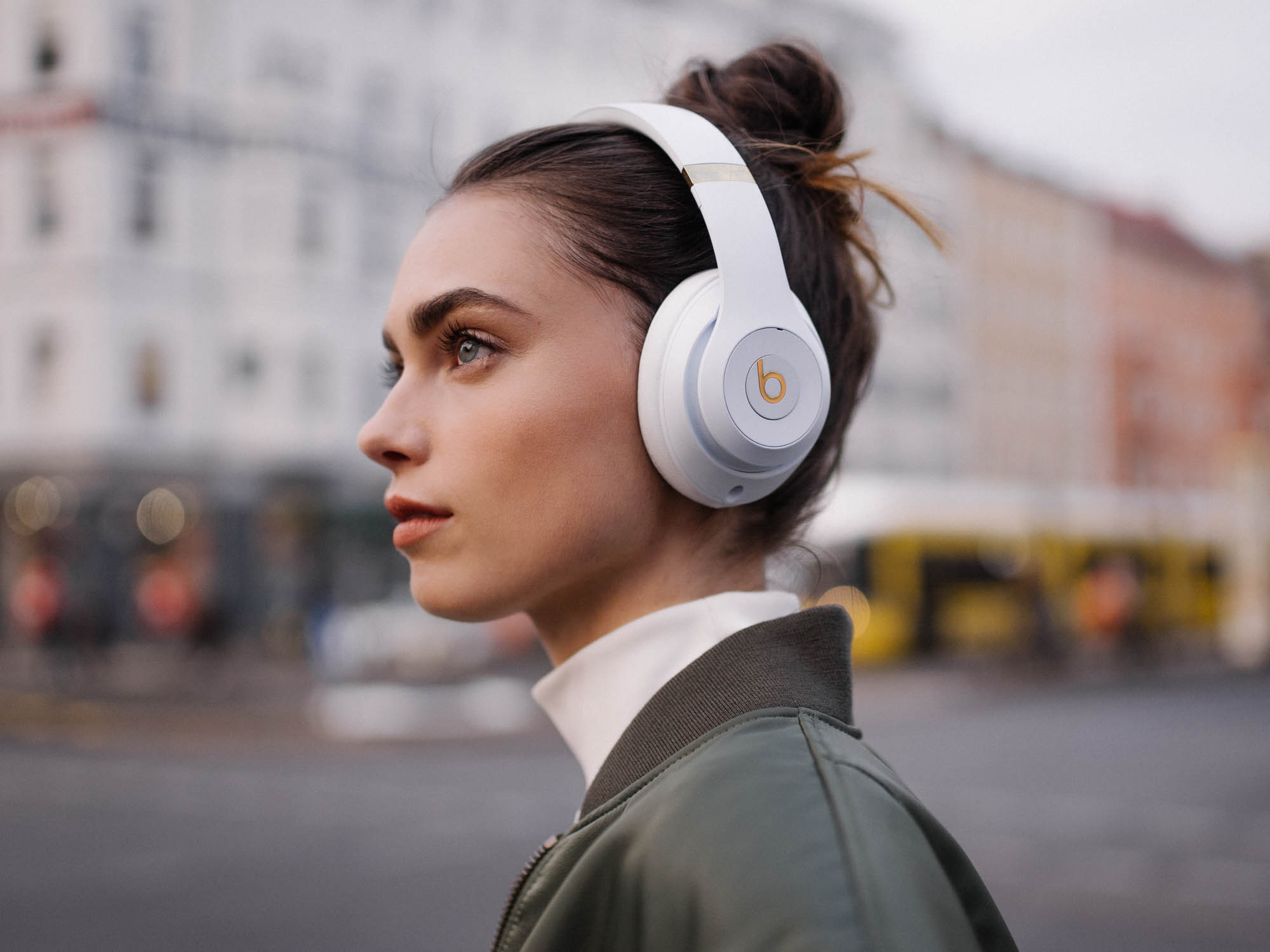 Uma mulher usando os fones de ouvido sem fio Beats Studio 3 ao ar livre.