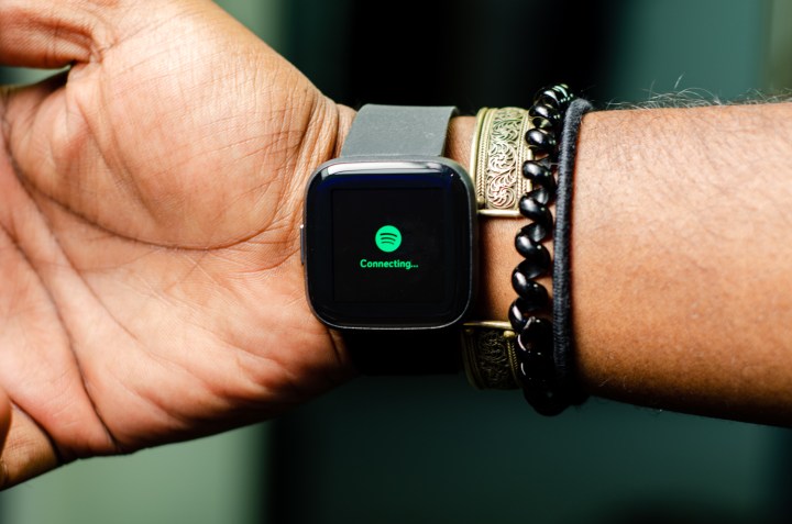 A person wearing a Fitbit Versa 2 with the Spotify app open.