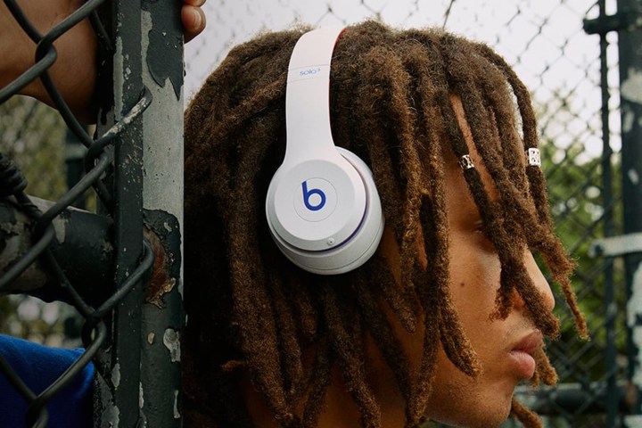 A woman wearing the Beats Solo3 wireless headphones in white.