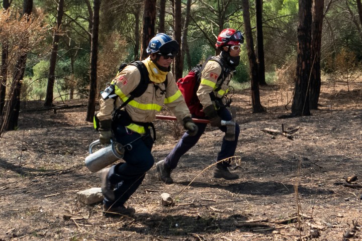 Firefighters running through the woods wearing Prometeo device