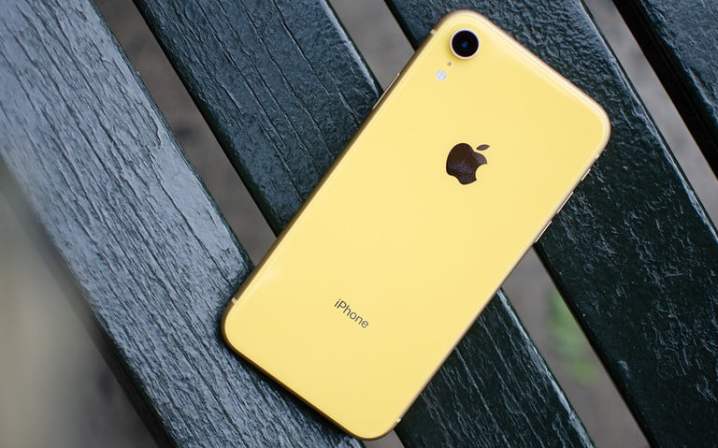 Yellow iPhone XR resting on a bench