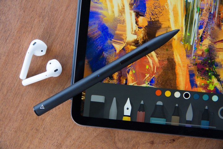 The Adonit Note Plus stylus tablet alongside a tablet and earbuds.