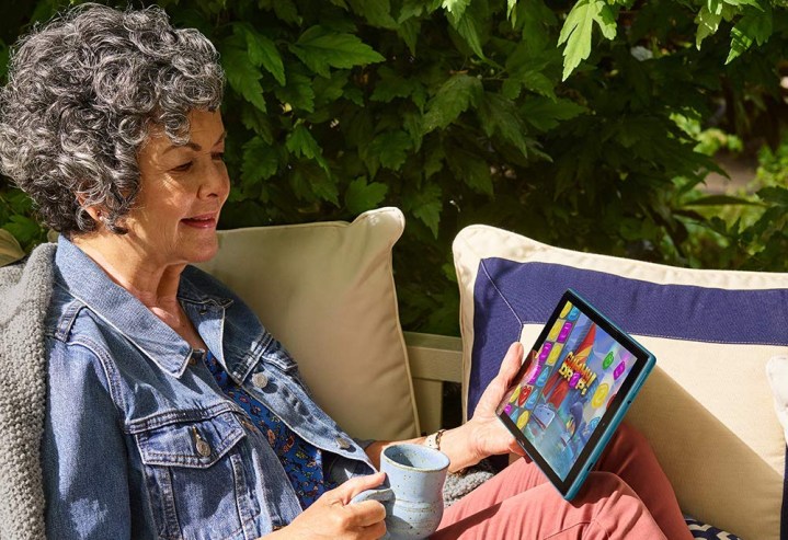 Una mujer mira contenido en una tableta Amazon Fire HD 10.