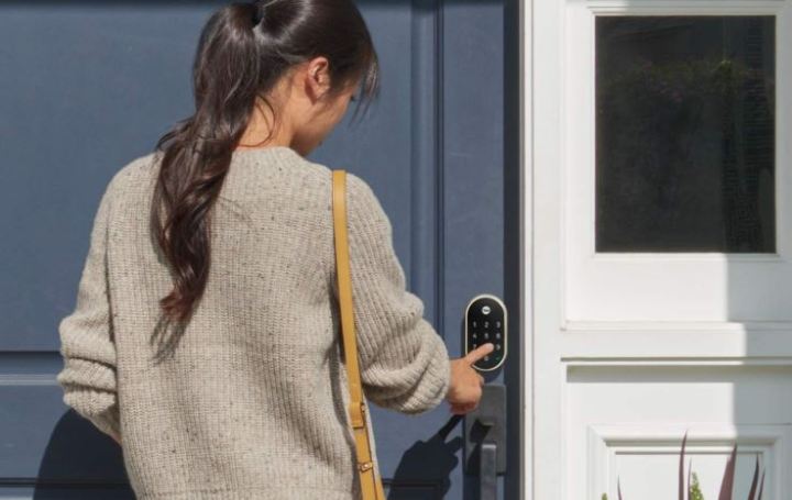 Man using a smart lock on a front door.