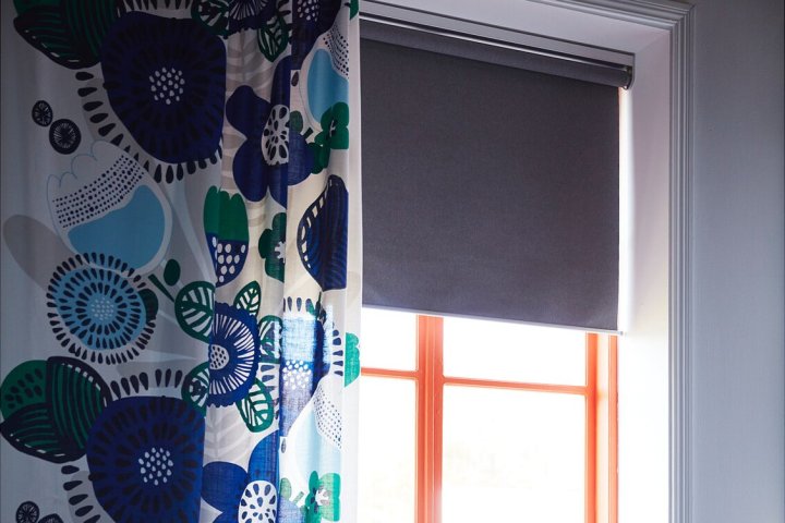 Persianas motorizadas de Ikea Frytur en una habitación con cortinas cerca.