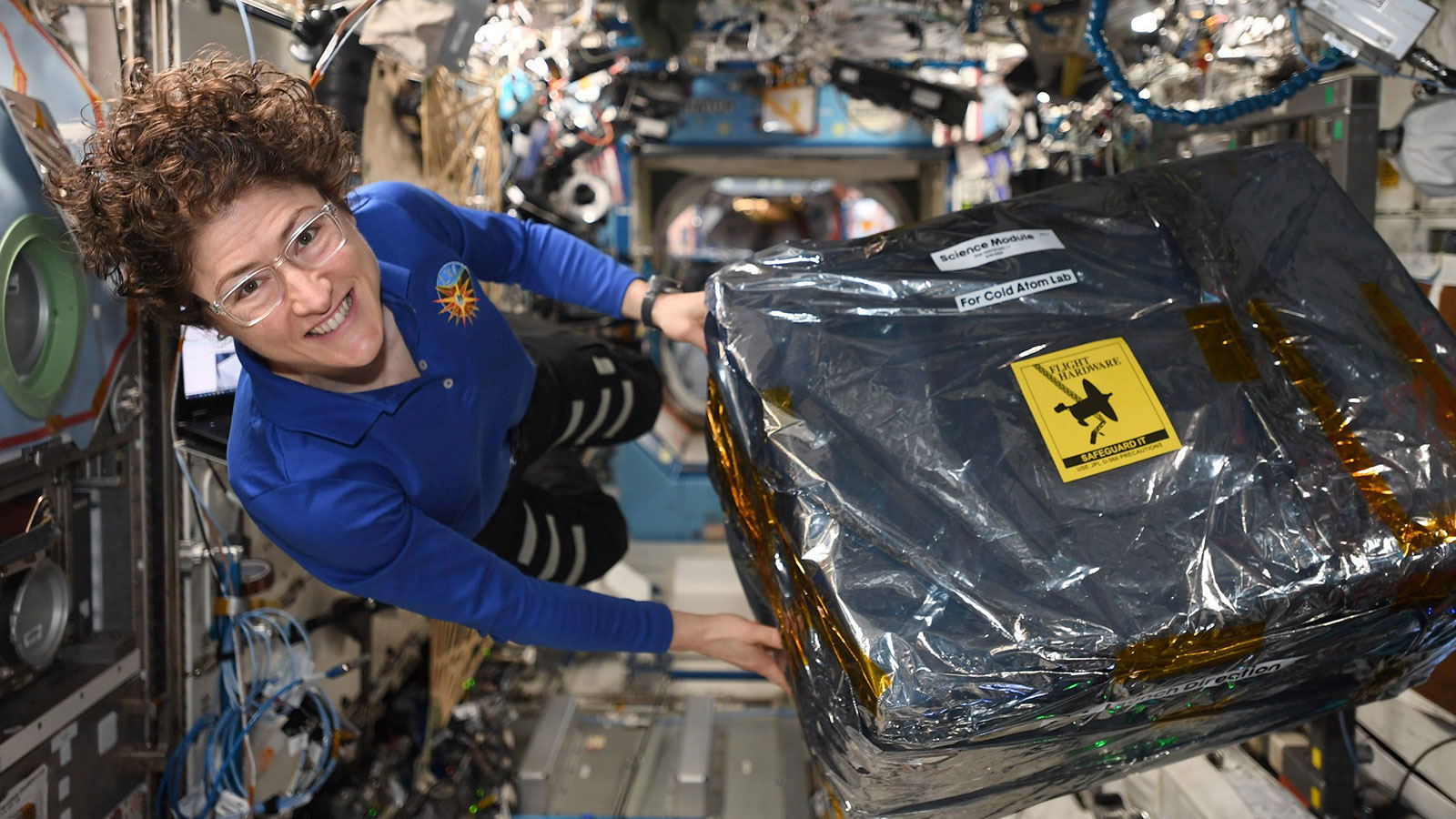 ISS astronaut Christina Koch unloads new hardware for the Cold Atom Lab.