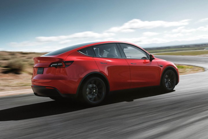 Μια απόδοση του Tesla Model 3 το δείχνει να οδηγεί σε έναν έρημο δρόμο.