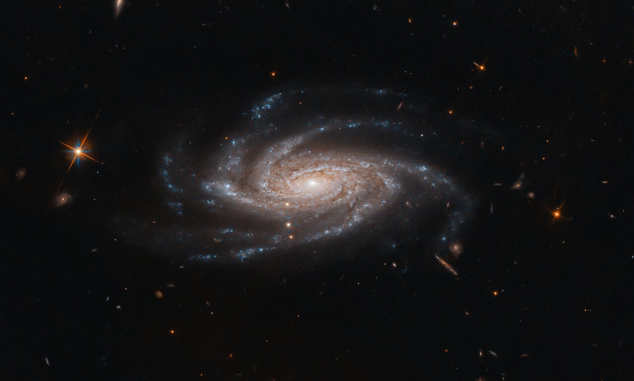 The spiral galaxy NGC 2008 sits centre stage, its ghostly spiral arms spreading out towards us, in this image captured by the NASA/ESA Hubble Space Telescope. 