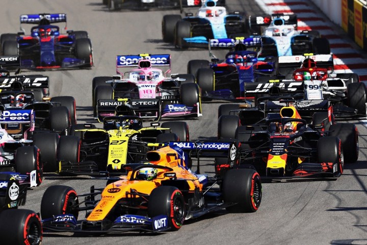 Formula One racing cars rounding a corner.