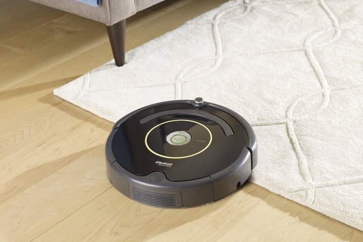 iRobot Roomba 614 di atas karpet dan lantai kayu.