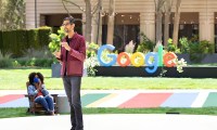 Sundar Pichai stands in front of a Google logo at Google I/O 2021.