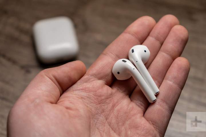 The Apple AirPods 2 in someone's hands.