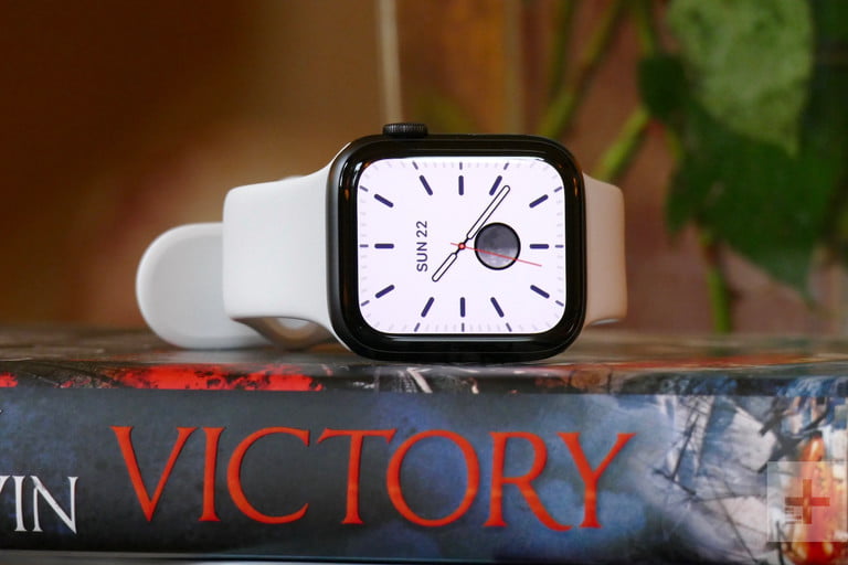 An Apple Watch Series 5 laying on a book.