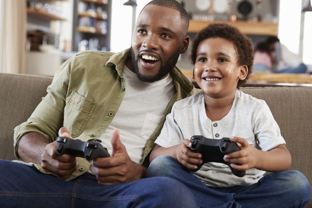 Fader och son som spelar videospel