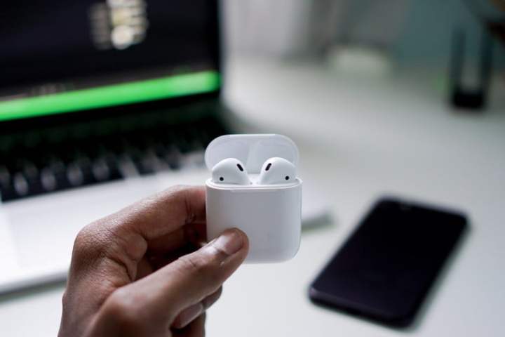 Apple AirPods held in hand.