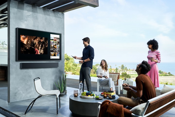 A family watching an outdoor TV.