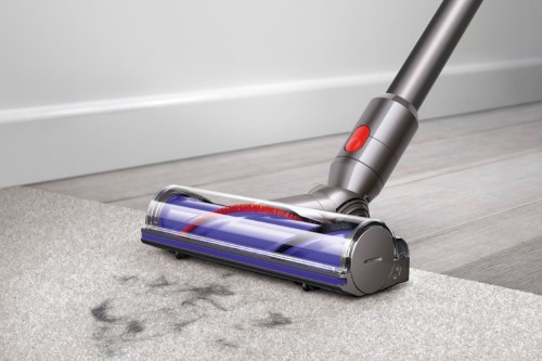 The Dyson V7 Animal cordless vacuum picking up dirt from the floor.