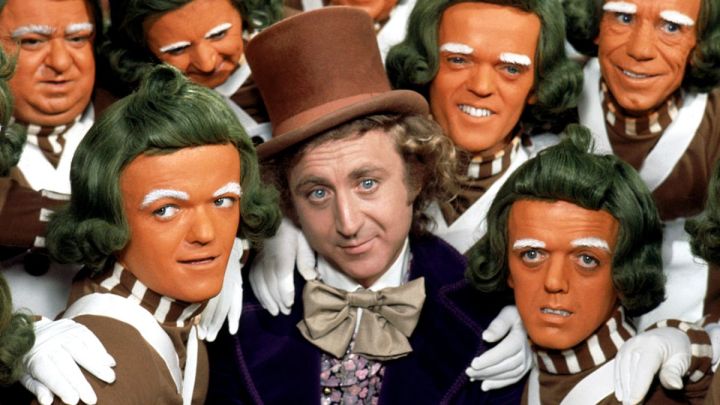 A man is surrounded by orange little people in Willy Wonka and the Chocolate Factory.