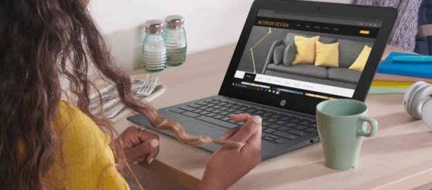 A woman in a yellow jumper sits at a desk with an HP Chromebook 11.6 open in front of her, and a mug alongside.