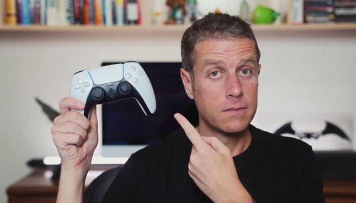 Geoff Keighley holding a dualsense controller.