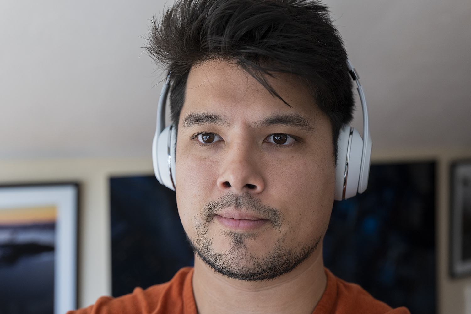 Reviewer wearing white Beats Solo3 wireless headphones.