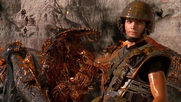 A soldier destroys a bug in Starship Troopers.