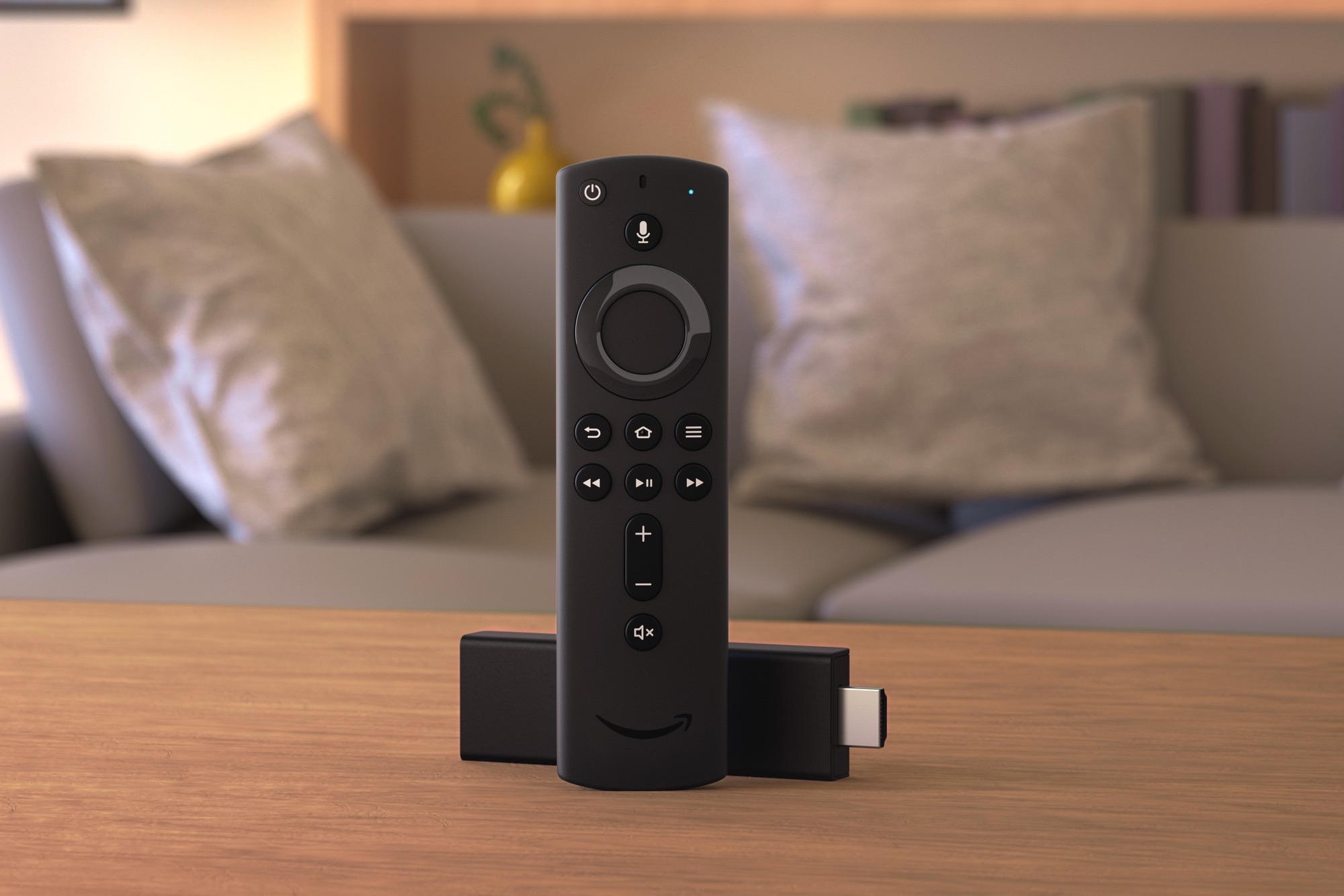 Amazon Fire TV Stick и пульт дистанционного управления лежат на столе в гостиной.