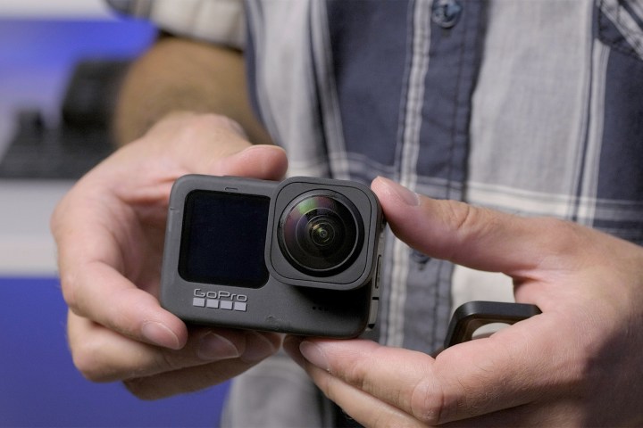 A person holding the GoPro Hero 9 against their side.