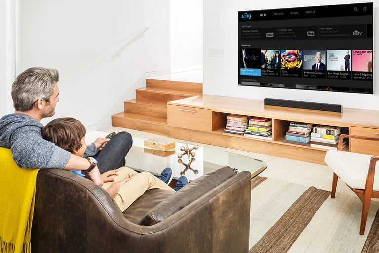 A man watching Sling TV in his living room.