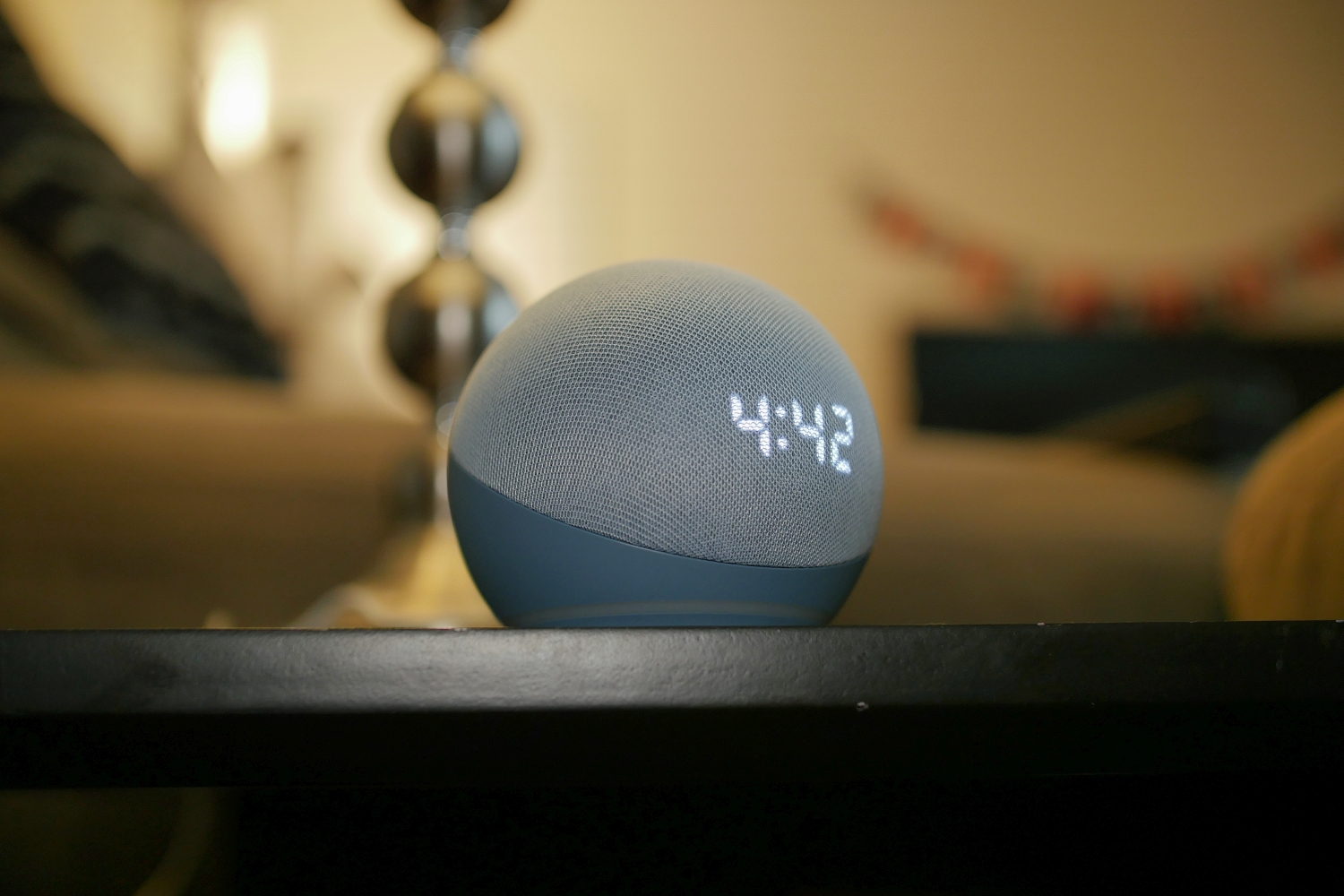 Amazon Echo Dot (4ª geração) com relógio na mesa.