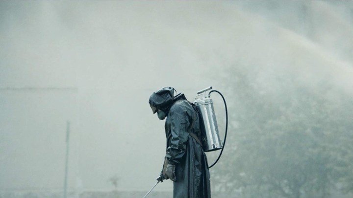 A man in a hazmat suit sprays wter.