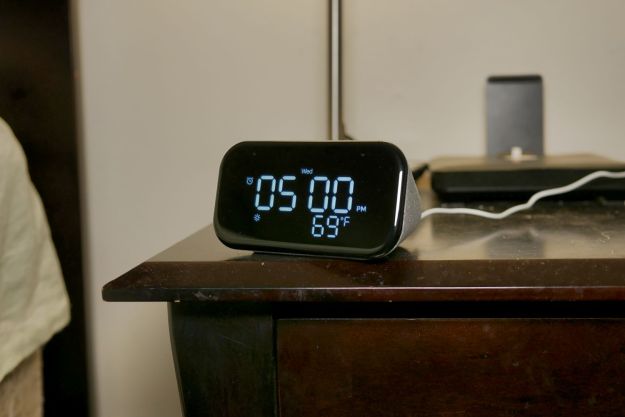 A Lenovo Smart Clock 2 placed on a bedside table.